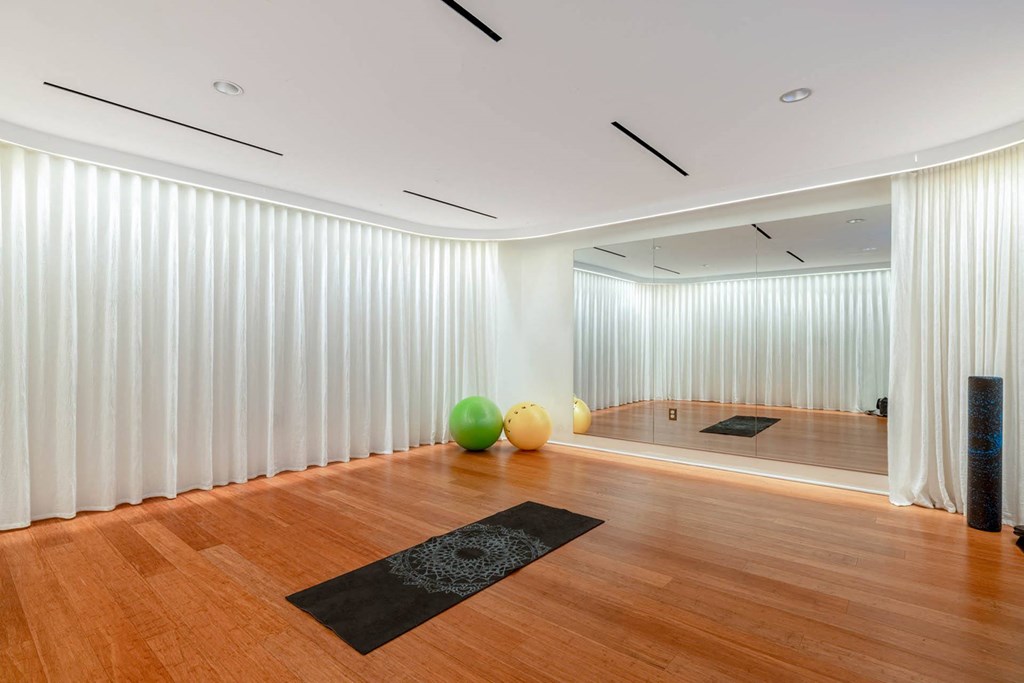 a large yoga room with white walls and wood floors