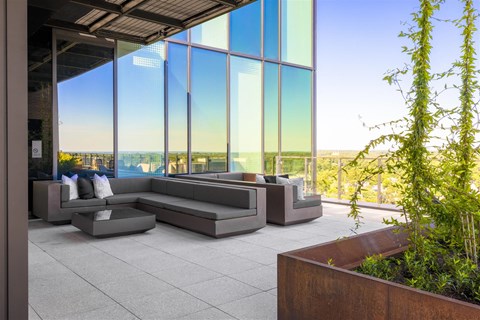 a lounge area with couches in front of a glass facade
