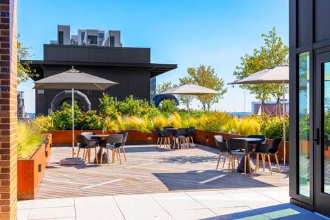 a roof terrace with tables and chairs and umbrellas