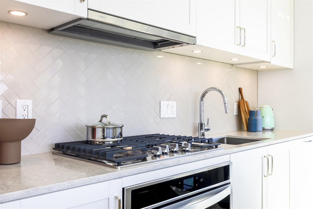 a kitchen with a stove top oven and a sink