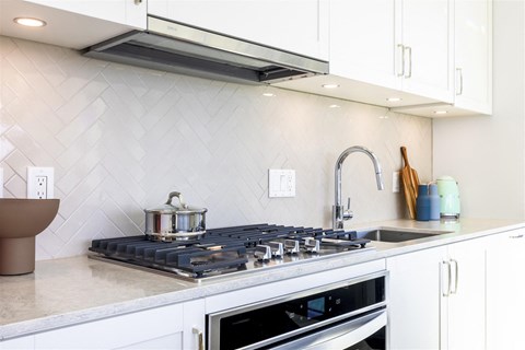 a kitchen with a stove top oven and a sink