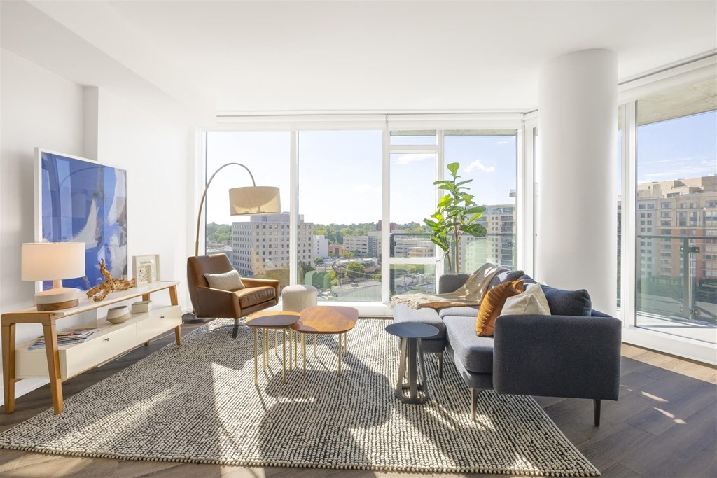 a living room with a large window and a couch and a rug