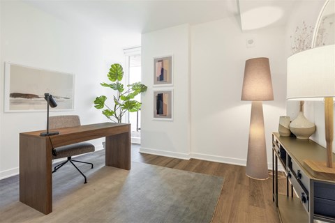 a home office with a desk and a large lamp