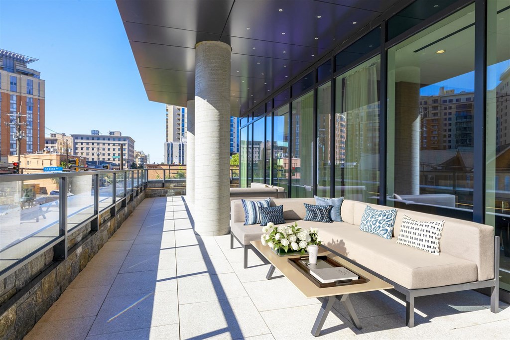a terrace with couches and a coffee table on a balcony