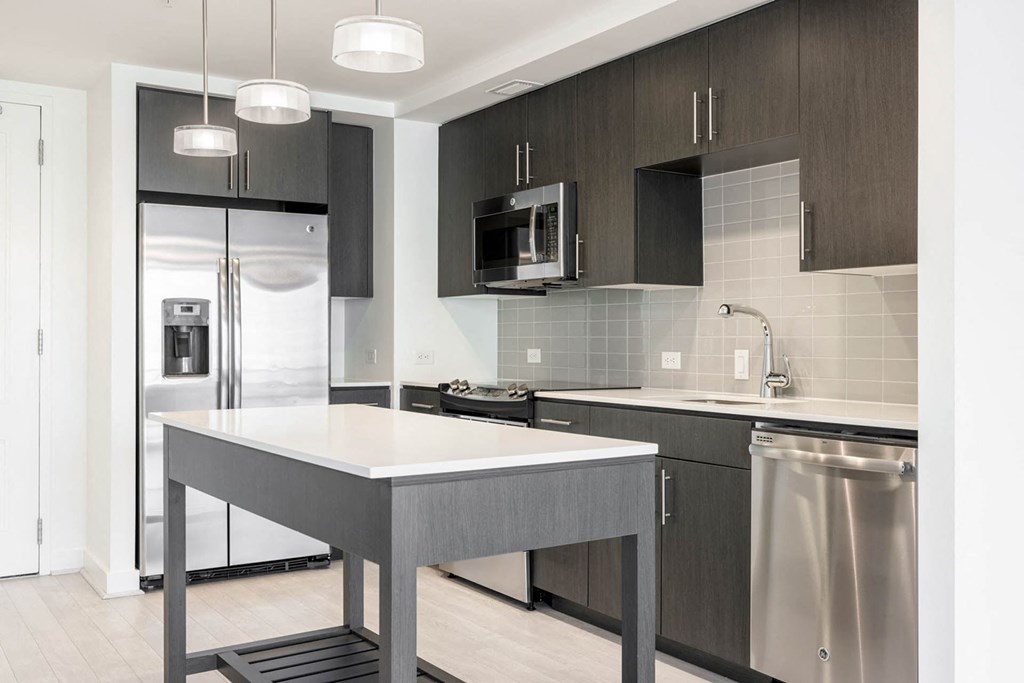 a kitchen with a large island and stainless steel appliances