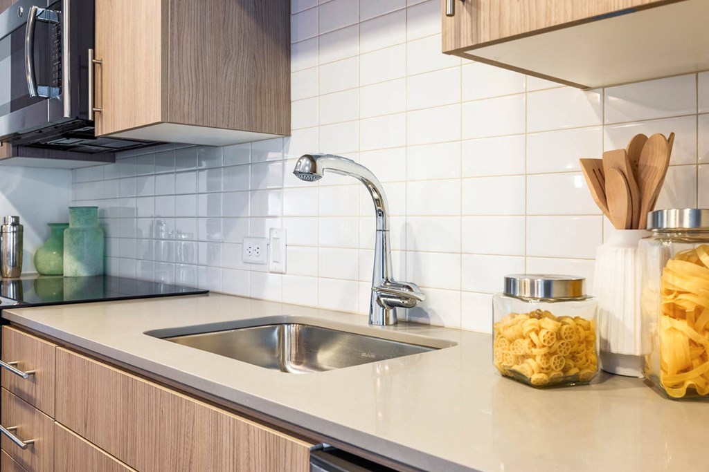 a kitchen with a sink and a jar of food on the counter