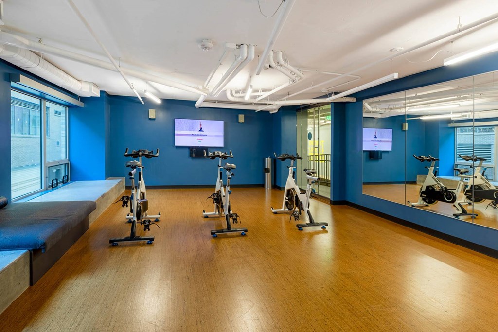a gym with exercise equipment and a tv on the wall