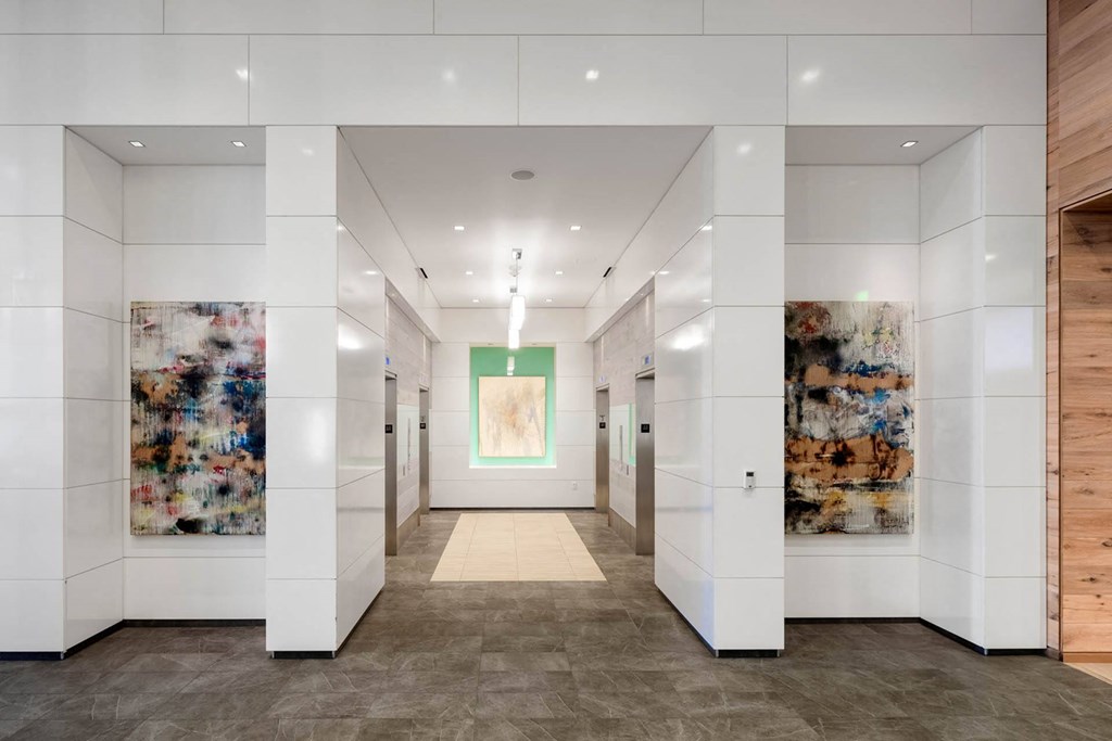 a hallway with white walls and art on the walls