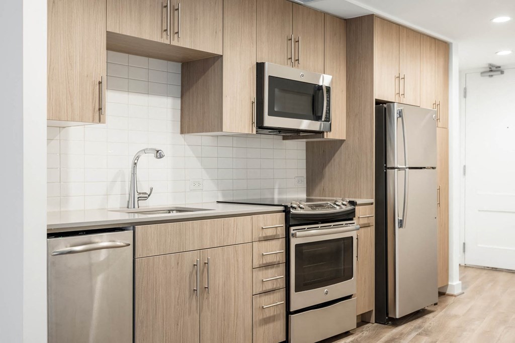 a modern kitchen with stainless steel appliances and wooden cabinets
