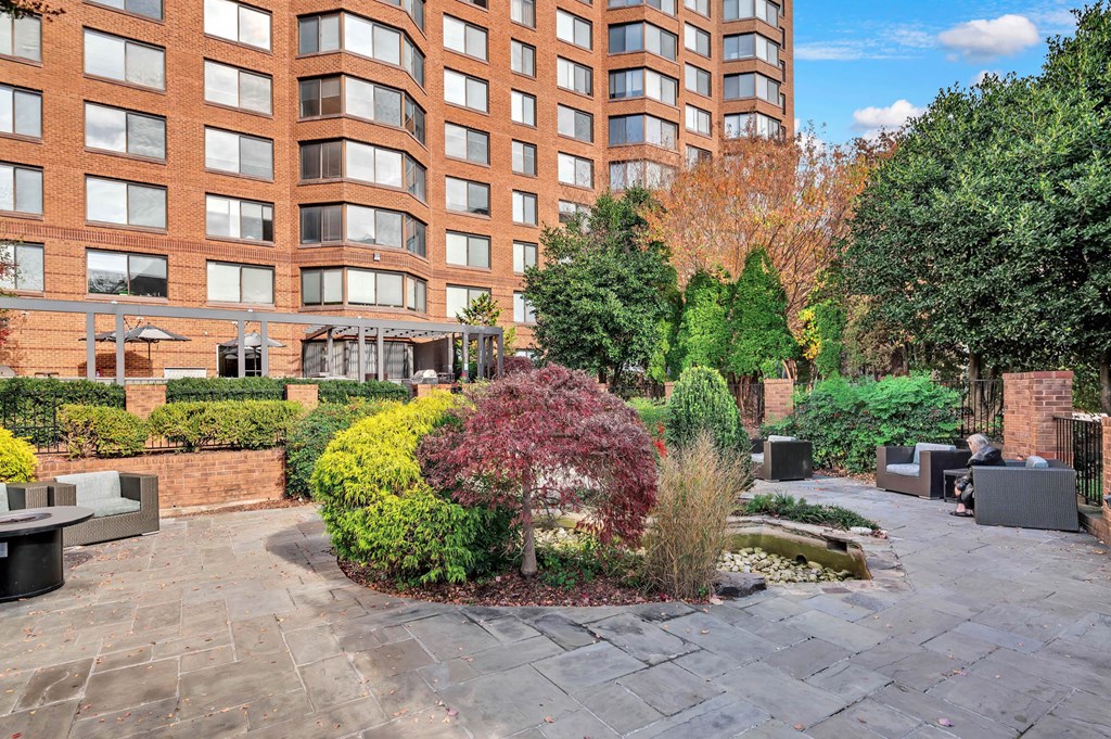 a courtyard with a building in the background and trees