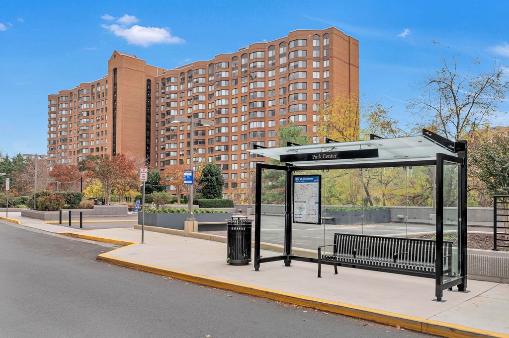 a bus stop with a large building in the background