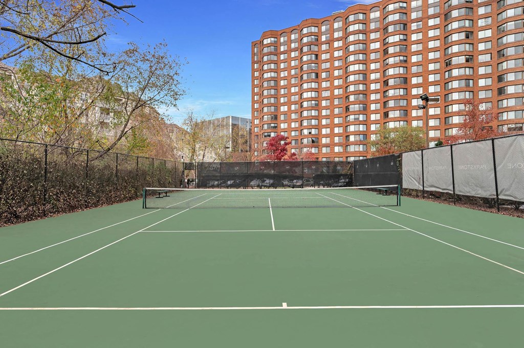 a tennis court with a building in the background