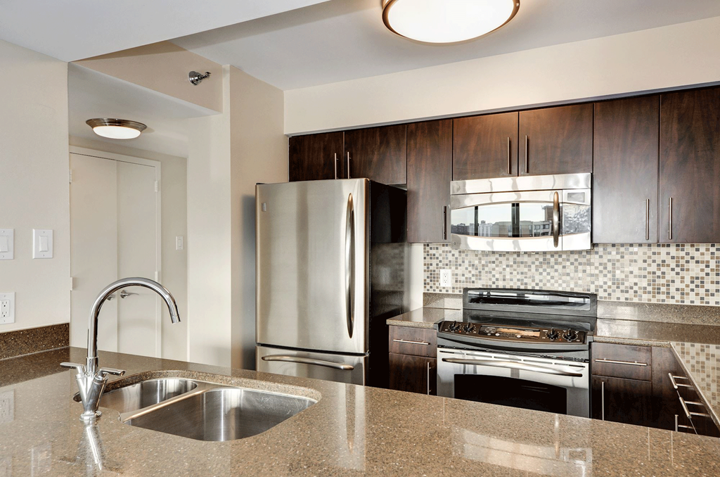 a modern kitchen with stainless steel appliances and granite counter tops