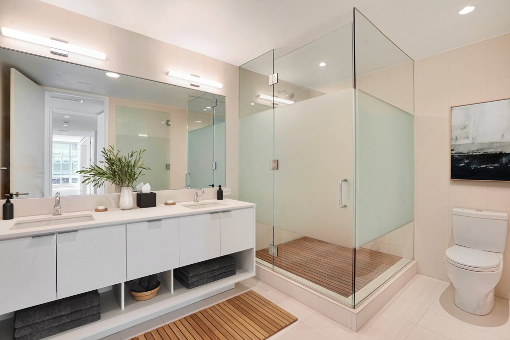 a bathroom with two sinks and a shower and a toilet