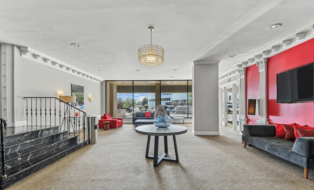 A modern living room with a black railing and a grey sofa.