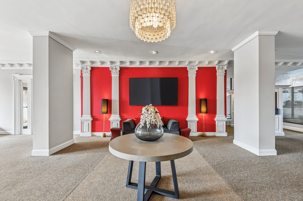 A large room with a round table and a chandelier hanging from the ceiling.
