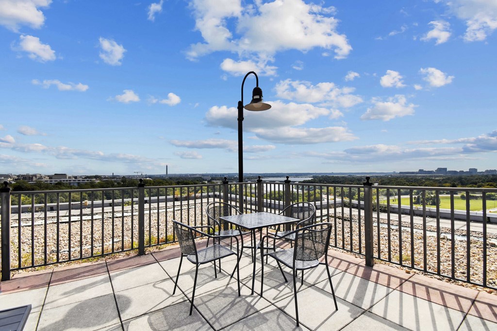 A patio with a table and chairs overlooking a field.