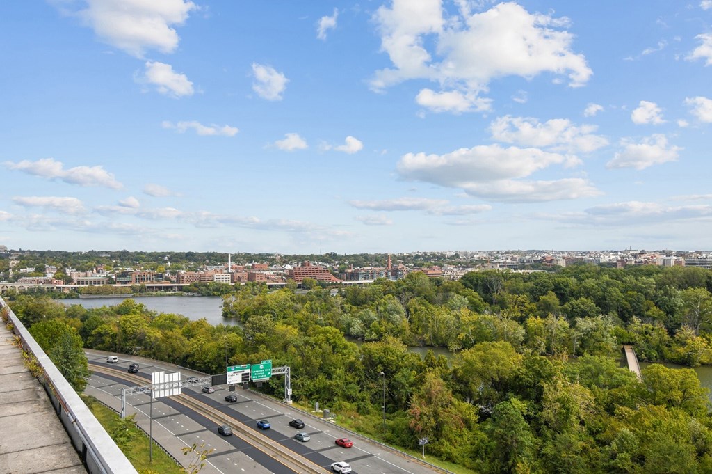 A highway with cars and a green sign in the distance.