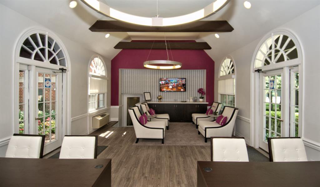 a living room with chairs and a table and a tv