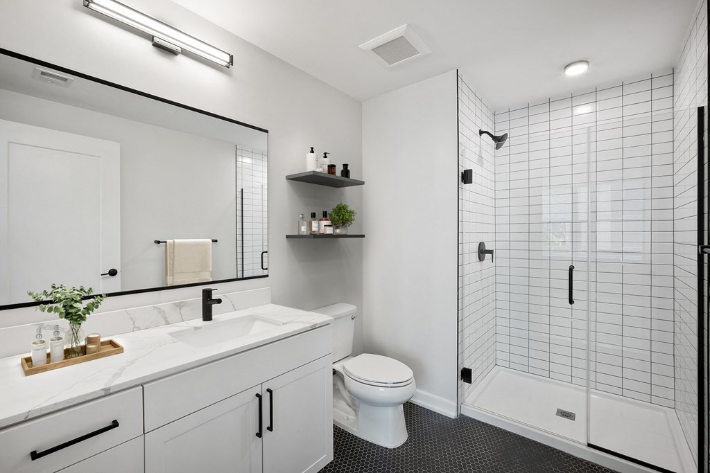 a white bathroom with a shower and a sink and a toilet