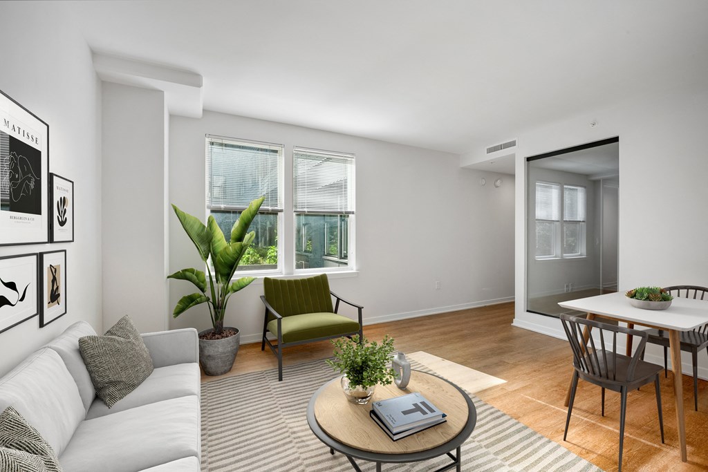 a living room with a couch and a coffee table and a dining room