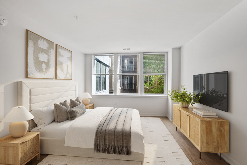 a white bedroom with a large bed and a window