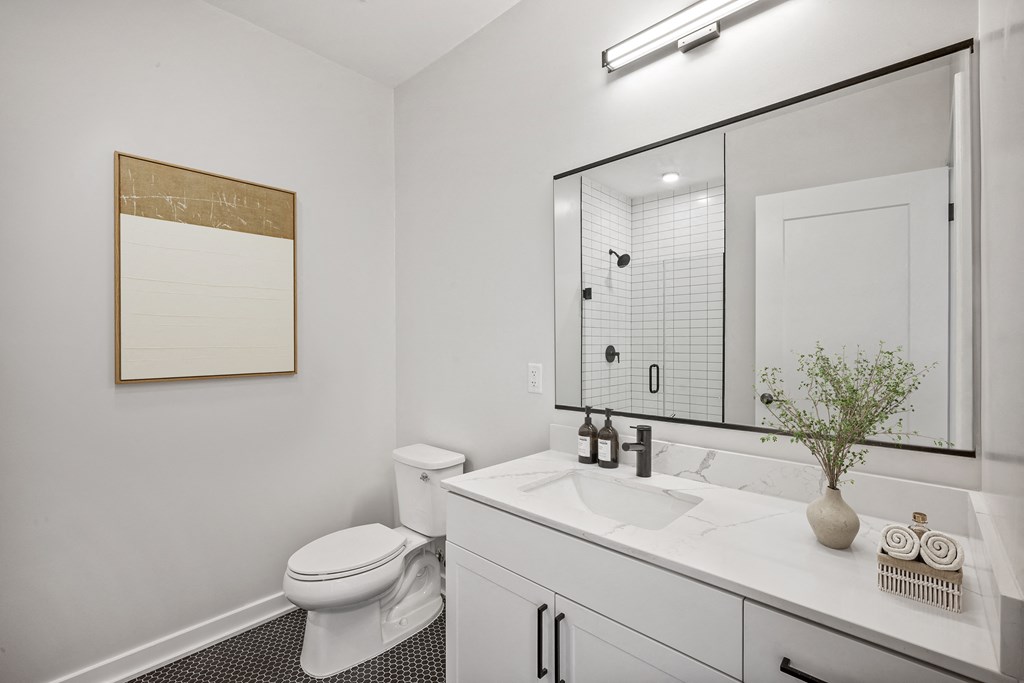 a bathroom with a large mirror and a toilet and a sink