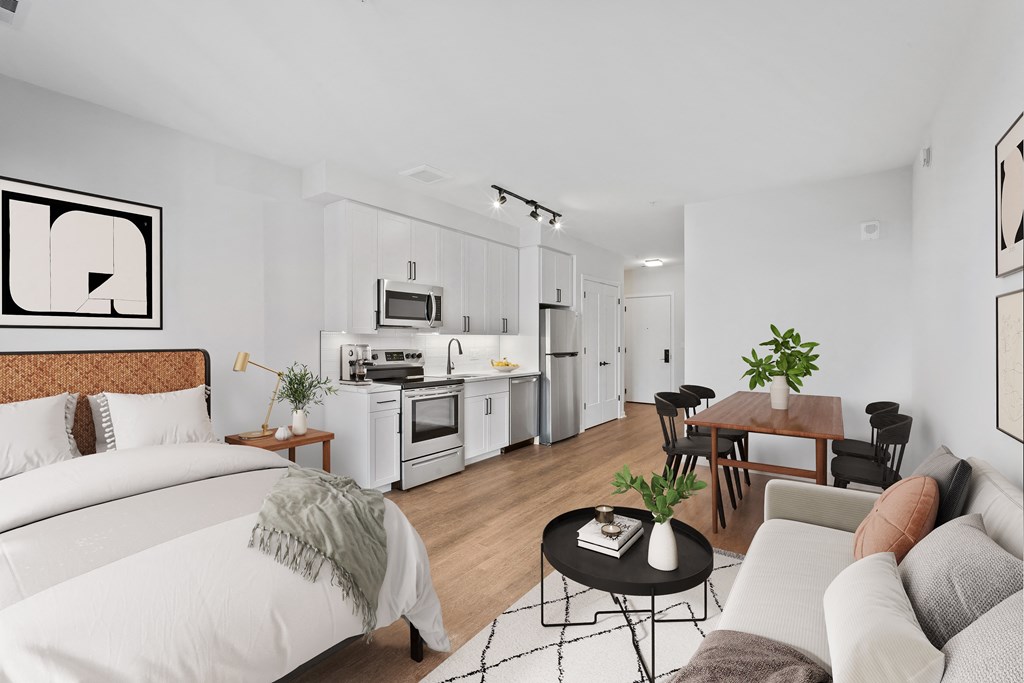 a bedroom with a bed and a couch and a kitchen