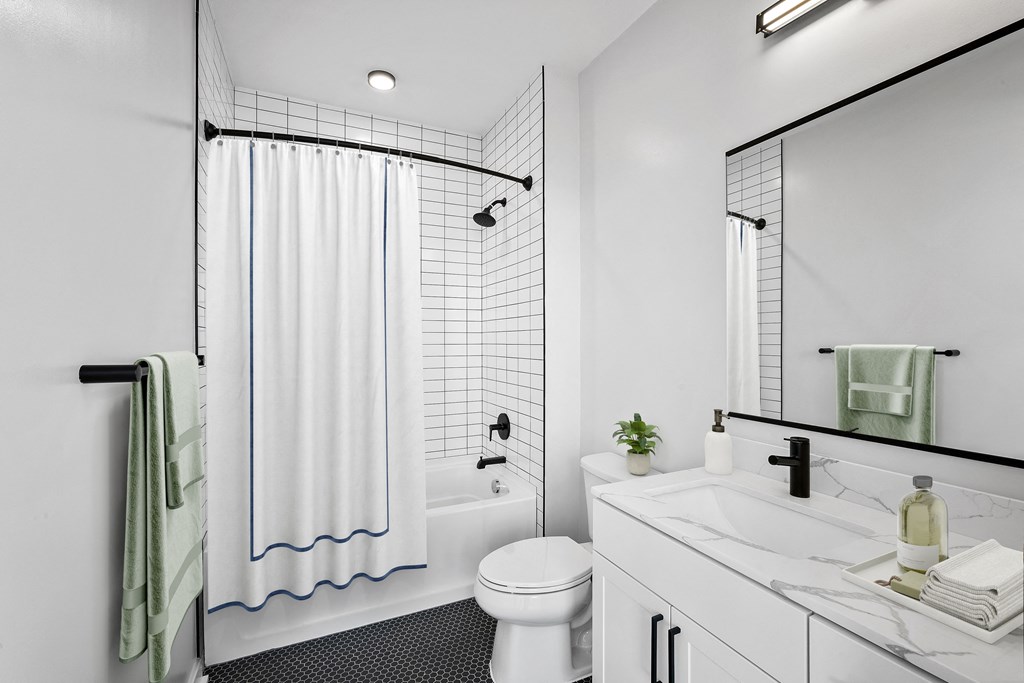 a white bathroom with a shower and a toilet and a sink