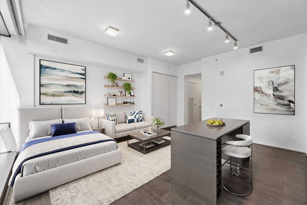 a bedroom with a bed and a desk and a living room