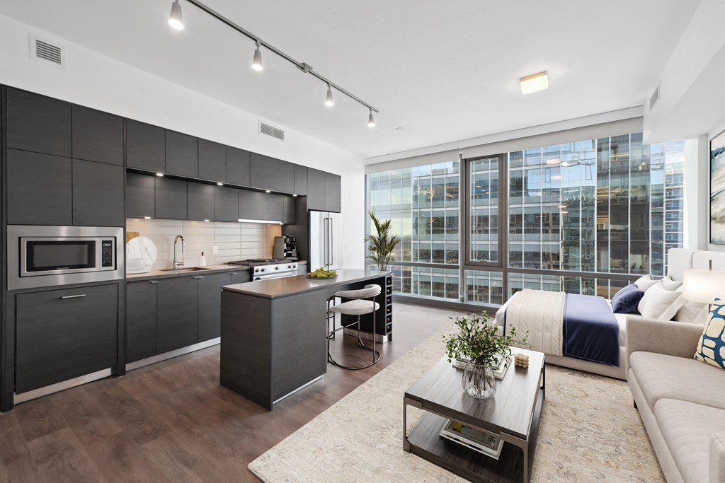 a living room with a kitchen and a bed