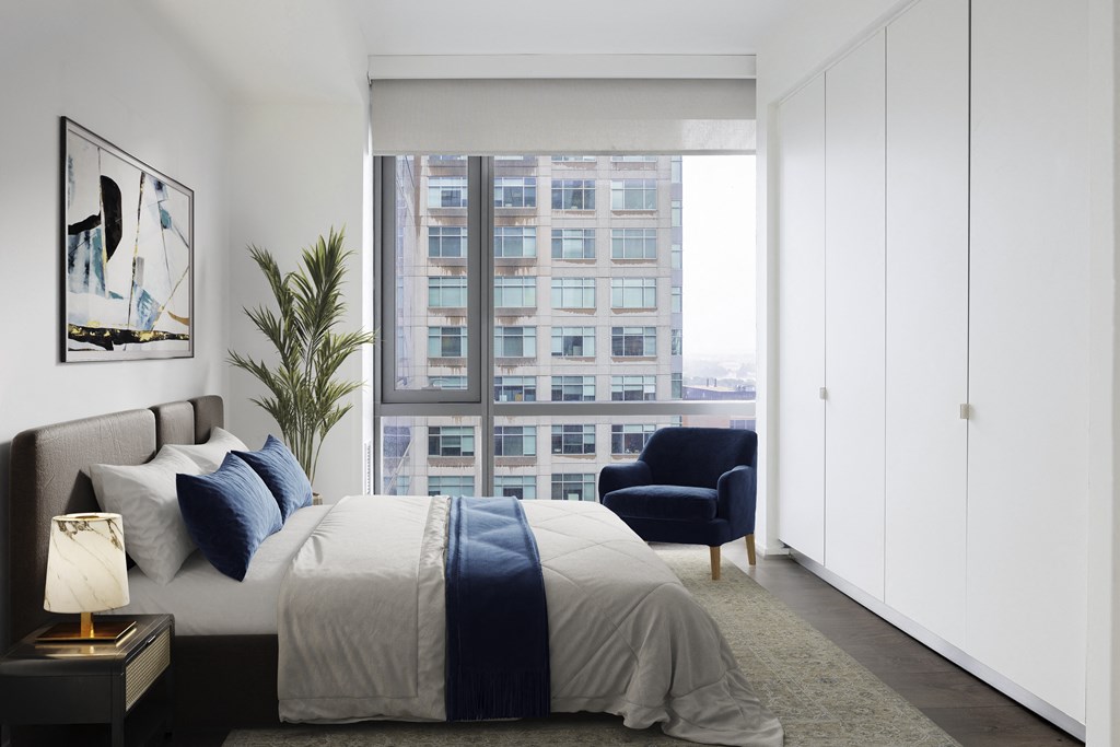 a bedroom with a bed and a large window