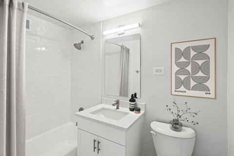 a bathroom with a toilet sink and shower and a mirror