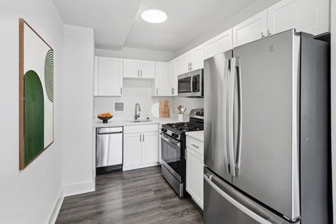 a kitchen with stainless steel appliances and white cabinets