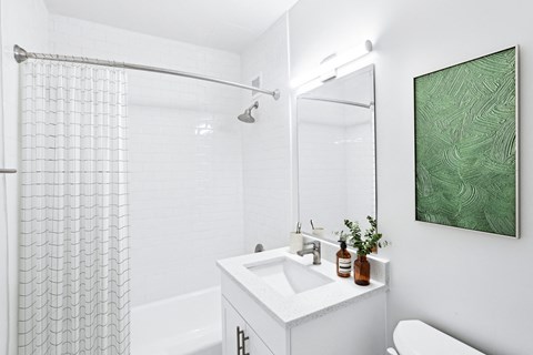 a white bathroom with a shower and a sink