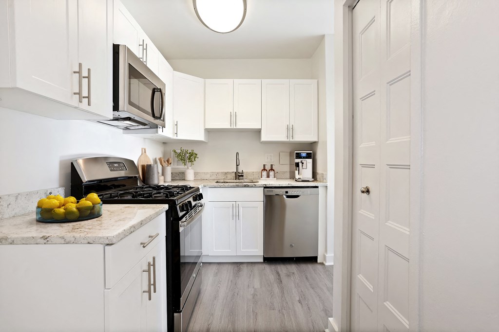 a kitchen with white cabinets and stainless steel appliances