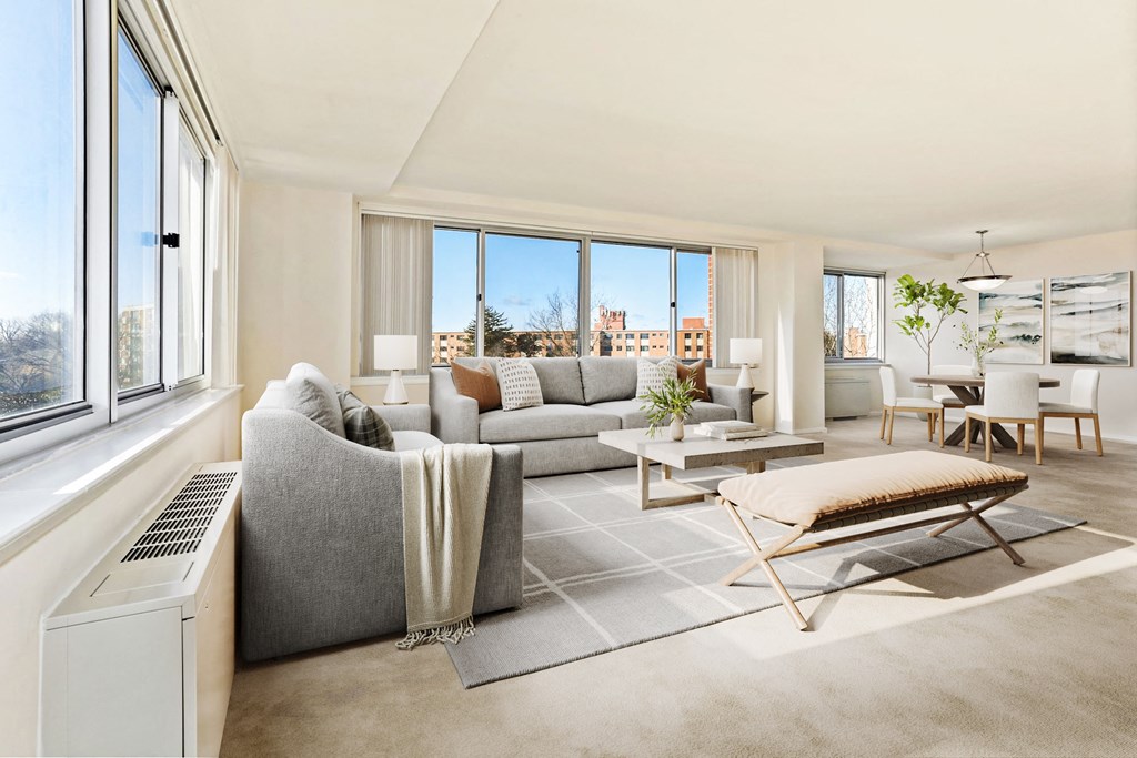a living room with a couch and a coffee table and large windows