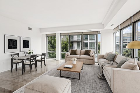 a living room with couches and a coffee table   and a dining table
