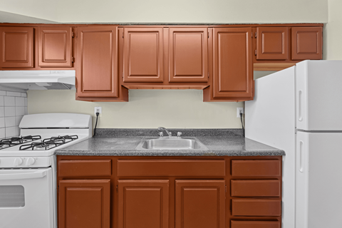 A kitchen with brown cabinets and a white refrigerator.