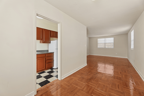 A kitchen with wooden floors and a checkered floor mat.