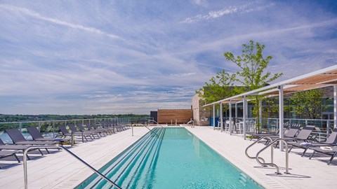 A large outdoor swimming pool with lounge chairs and a view of the horizon.