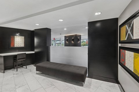A black and white hallway with a bench and a table.