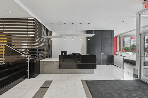A black and white reception area with a black counter and a black and white rug.