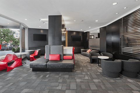 A modern lounge area with red and grey seating.