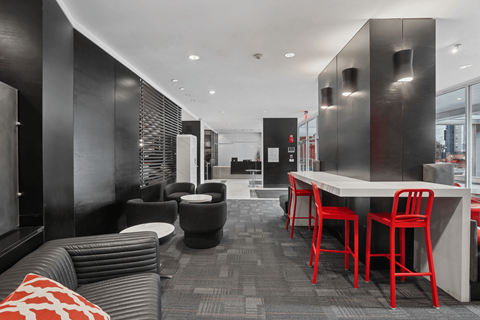 A black and red themed cafe with a long table and chairs.