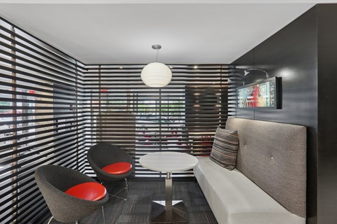 A modern living room with a grey couch, two chairs and a table.
