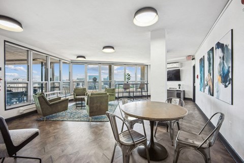 a living room with a table and chairs and a large window