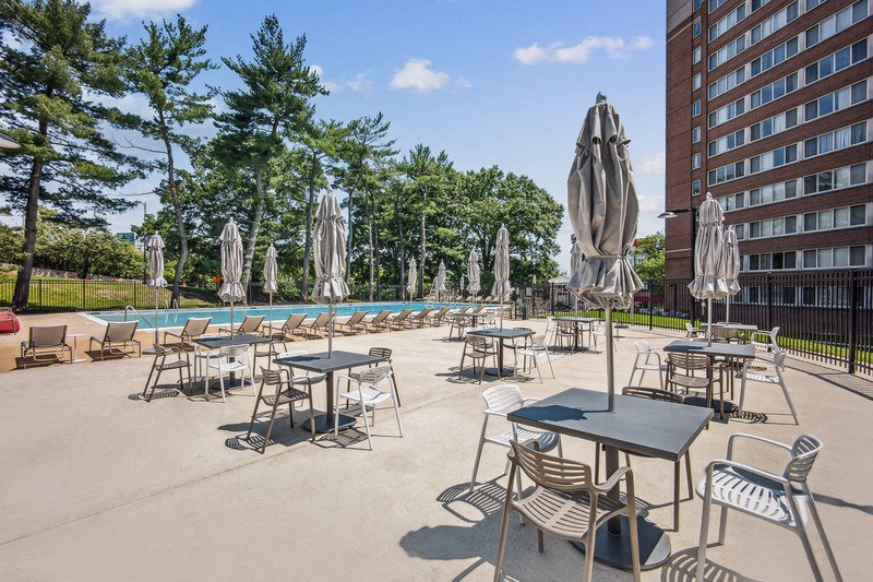 an outdoor patio area with tables and chairs and a swimming pool