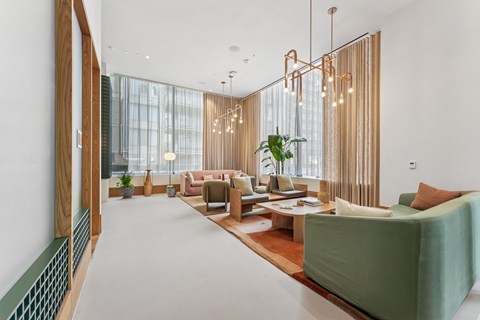 A modern living room with a green sofa and a wooden floor.