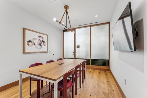 A dining room with a wooden table and chairs.
